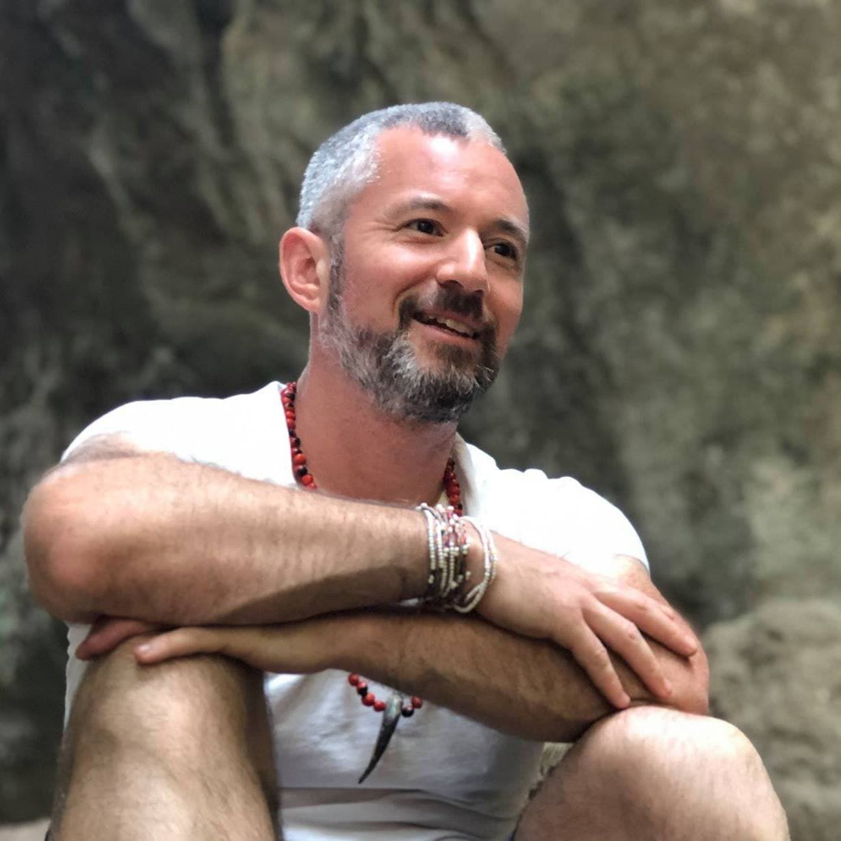 Portrait of Ameyalli smiling outdoors against a stone background